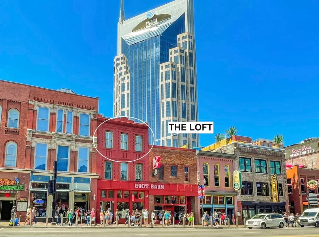 een groep gebouwen in een straat met een hoge wolkenkrabber bij Broadway Penthouse Above Live Music & Bars in Nashville