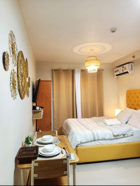 a bedroom with a bed and a table with plates on it at "Zen Spot" Saekyung Condo Unit in Lapu-Lapu City in Lapu Lapu City