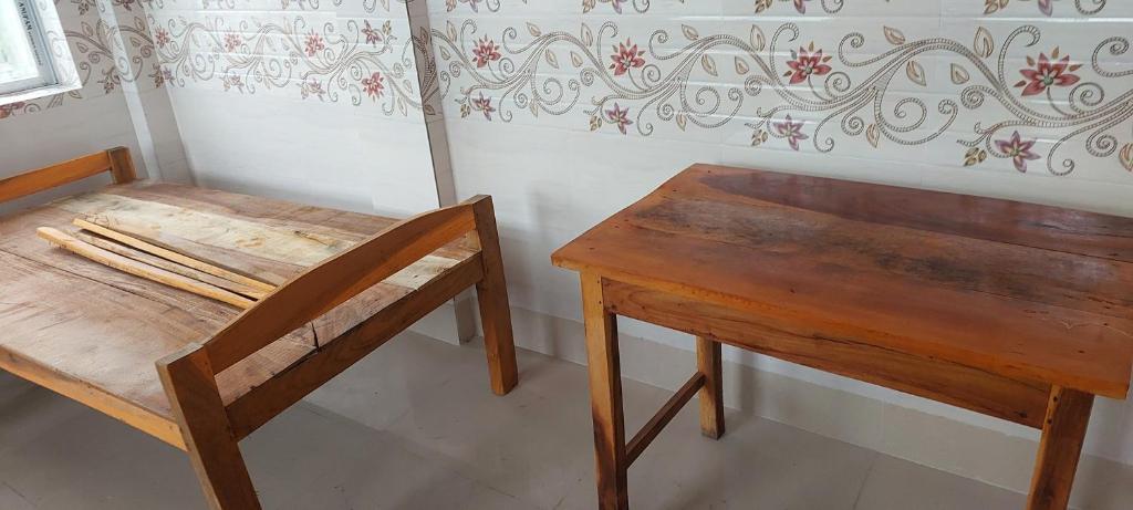 a wooden table and a wooden chair next to a table at MAA PG in Silchar