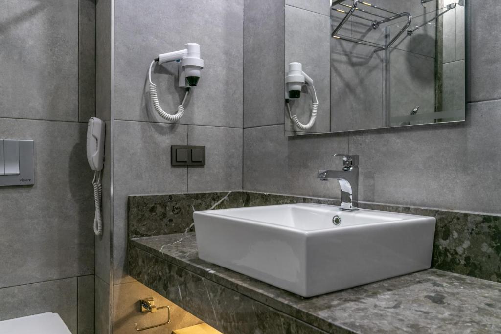 a bathroom with a large white sink and a phone at Lara Park Hotel in Antalya