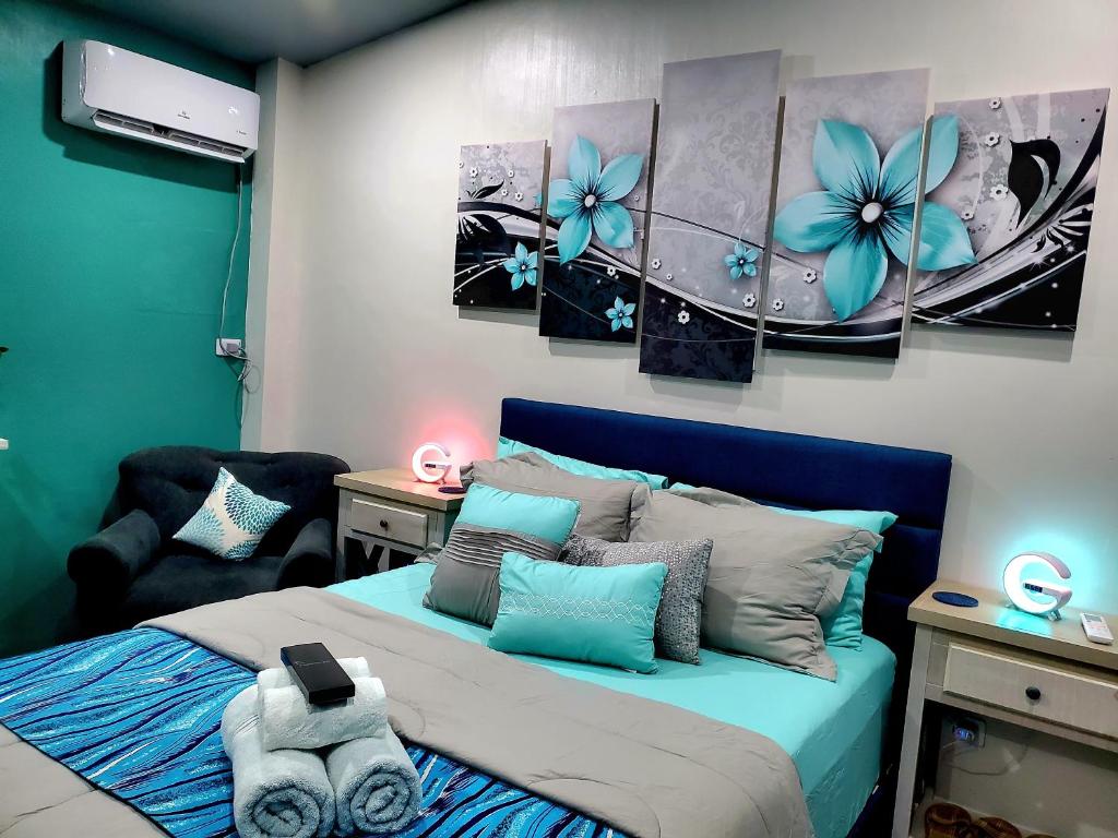 een slaapkamer met een blauw bed met bloemen erop bij Hidden Palms Inn in san juan la union