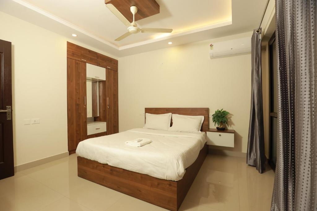 um quarto com uma cama e uma ventoinha de tecto em VV ROOMS cochin internationalairport em Nedumbassery