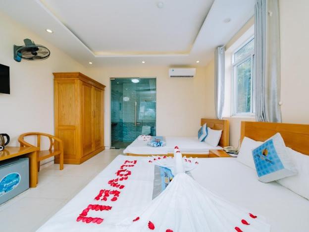 a room with two beds with red decorations on them at Lang Chai Hotel - Travel Agency in Cat Ba