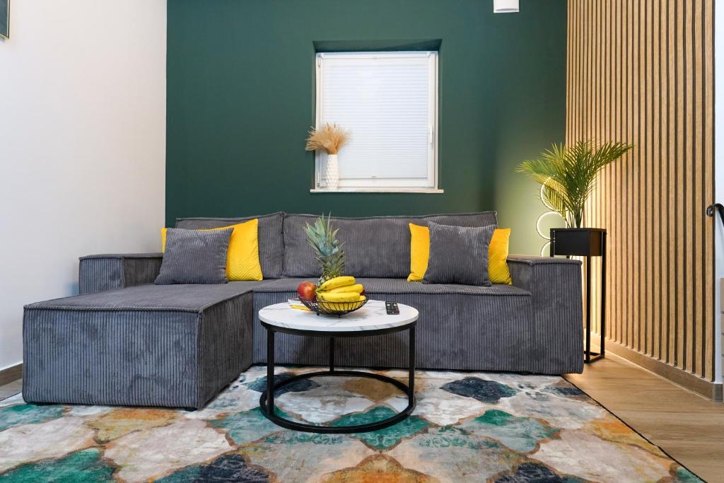 a living room with a gray couch and a table at CABANA Kreyenbrück - Maisonette Apartments - Parkplatz - Nähe Klinikum - Netflix in Oldenburg