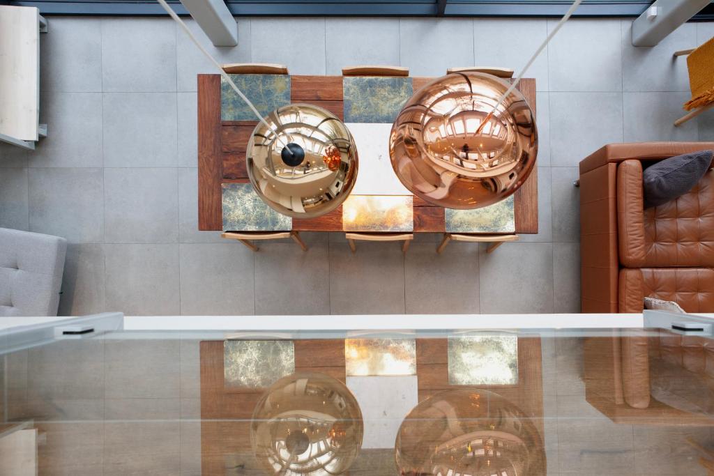 a glass table with three copper plates on a wall at high-Q in Kowalewo