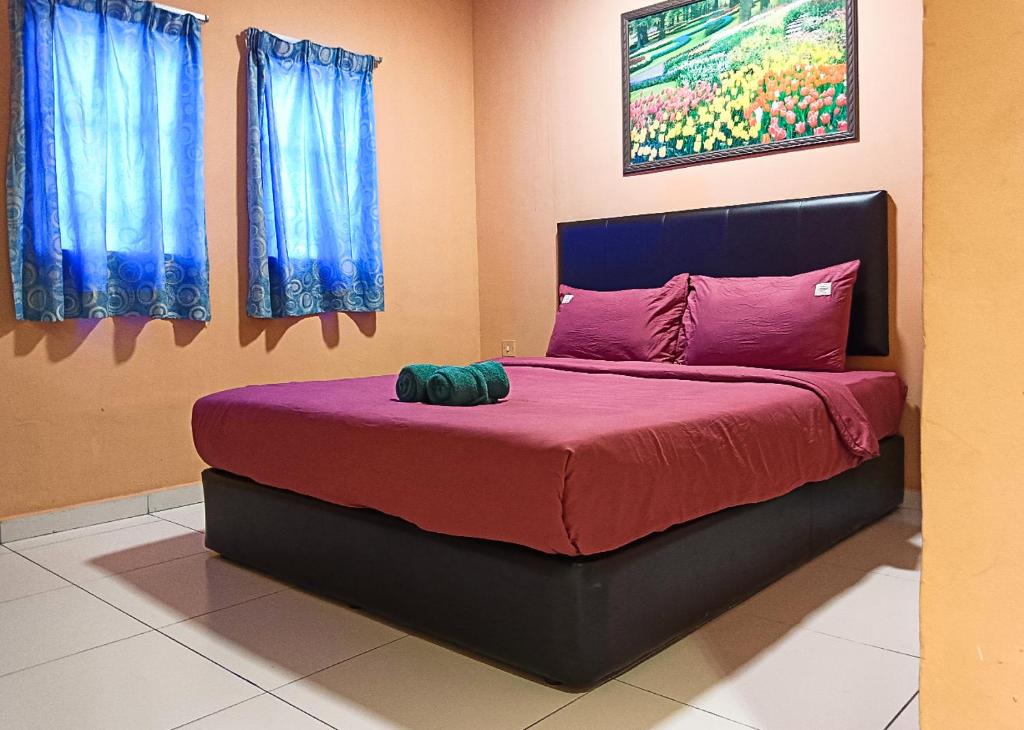 um quarto com uma cama grande e lençóis roxos em Hotel EC Double Star KLIA 1-KLIA 2 em Sepang