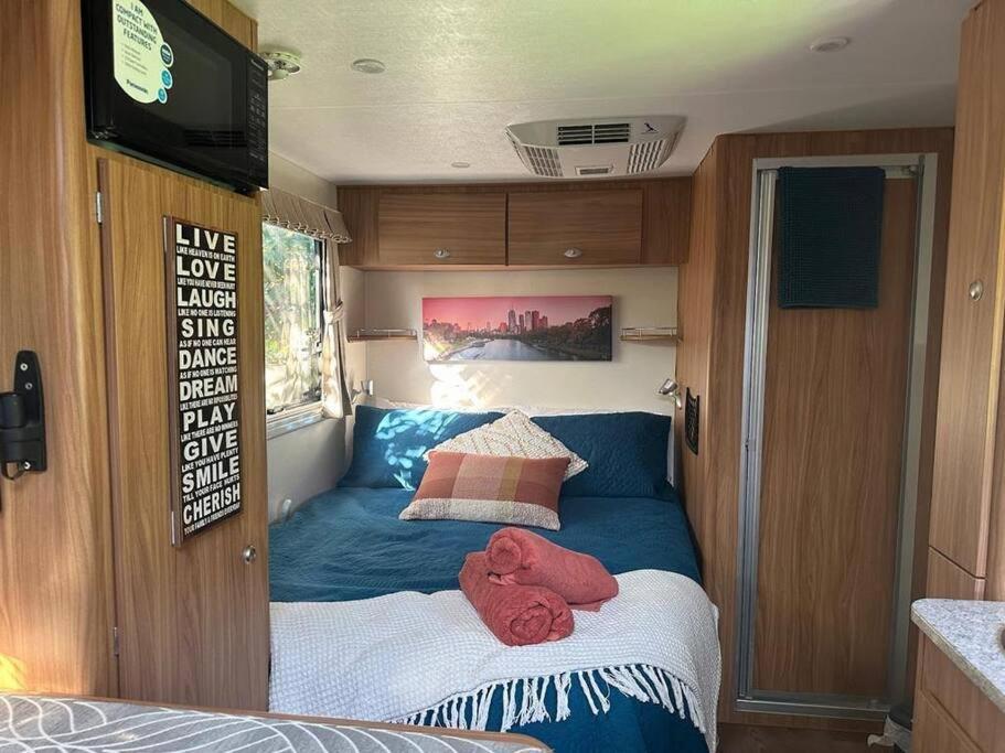 ein kleines Bett im hinteren Teil eines Wohngebäudes in der Unterkunft Heated Caravan with all the trimmings in Melbourne