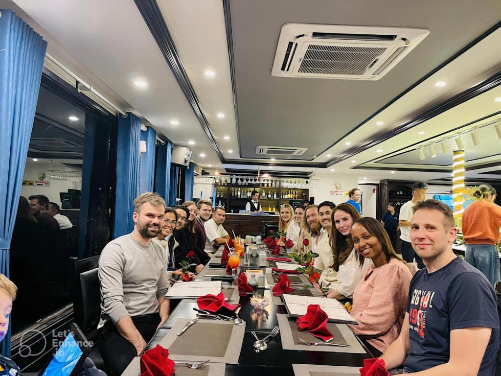 a group of people sitting at a long table at Calet Hotel in Cat Ba