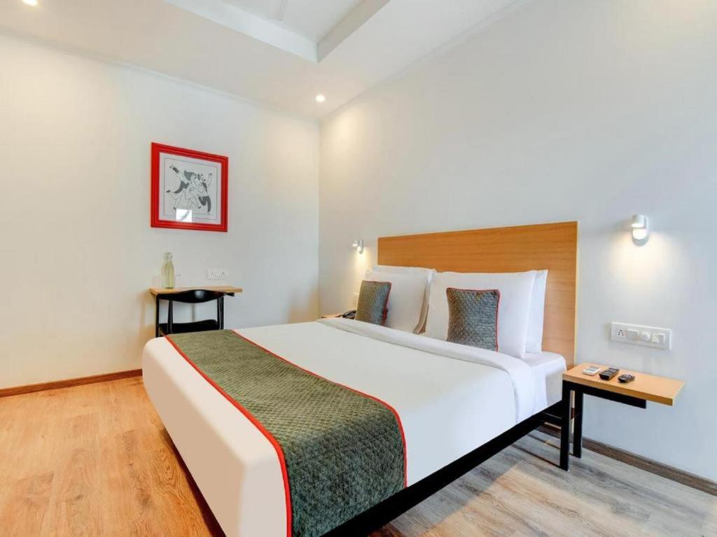 una camera d'albergo con un grande letto e un tavolo di HOTEL CHETRAM ELITE near railway station a Jaipur