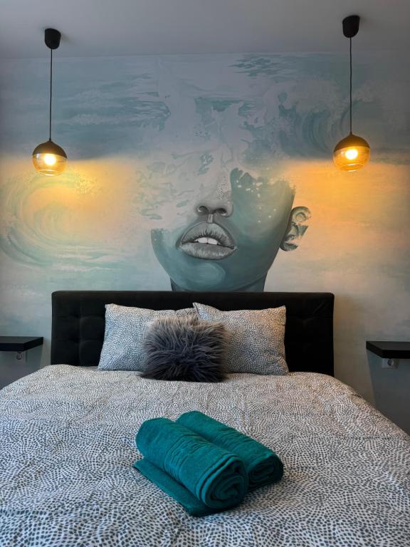a bedroom with a bed with a painting of a woman at BLACK APARTAMENT in Cluj-Napoca