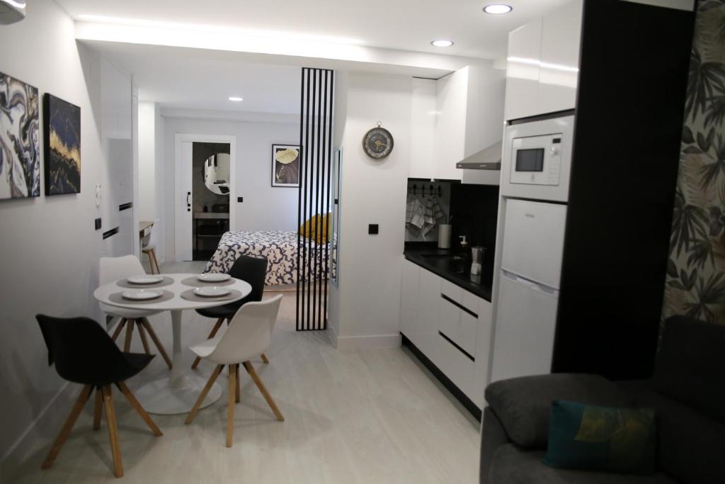 a kitchen and a living room with a table and chairs at E&R-1 Plaza España in Salamanca