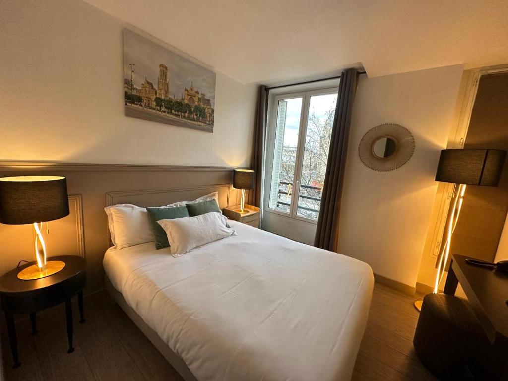 Schlafzimmer mit einem großen weißen Bett und einem Fenster in der Unterkunft Hotel Little Regina in Paris