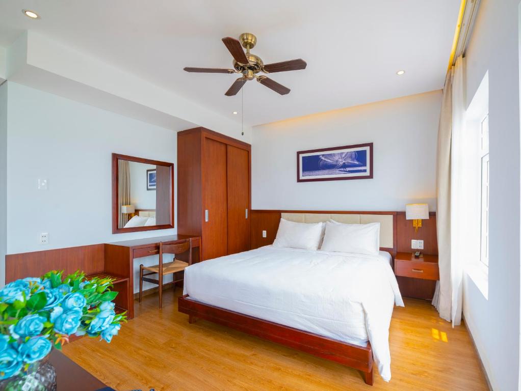 - une chambre avec un lit et un ventilateur de plafond dans l'établissement Di Lusso Boutique Riverside Danang Hotel, à Đà Nẵng