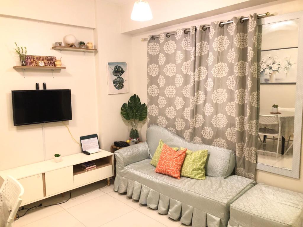 a living room with a couch and a tv at Casi Cozy Spacious Condo For Family, Free Wifi, Netlfix and Pool in Davao City