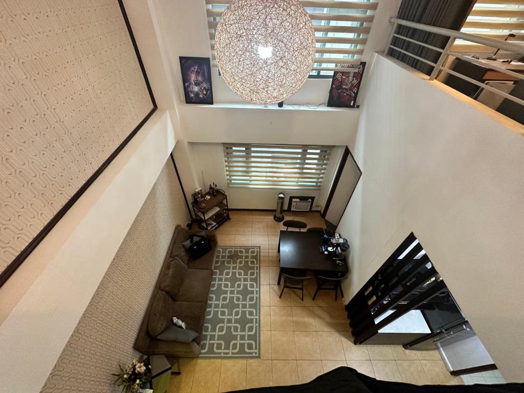 una vista aérea de una sala de estar con una escalera en The Pearl - BGC McKinley Park 2BR en Manila