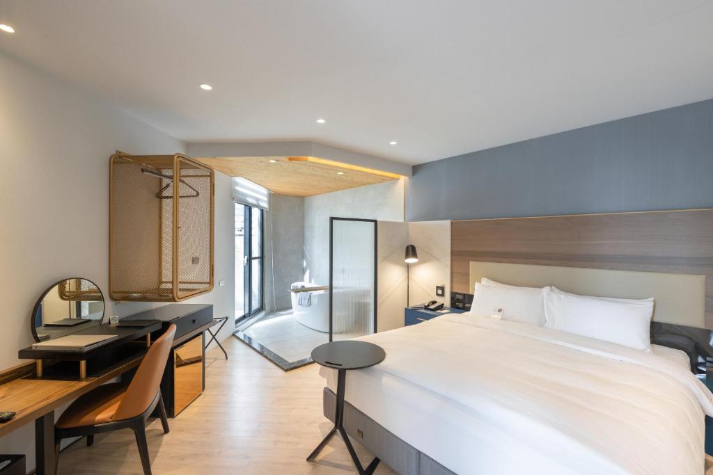 een hotelkamer met een groot bed en een bureau bij 墾丁耳東華苑ErDong Manor in Kenting