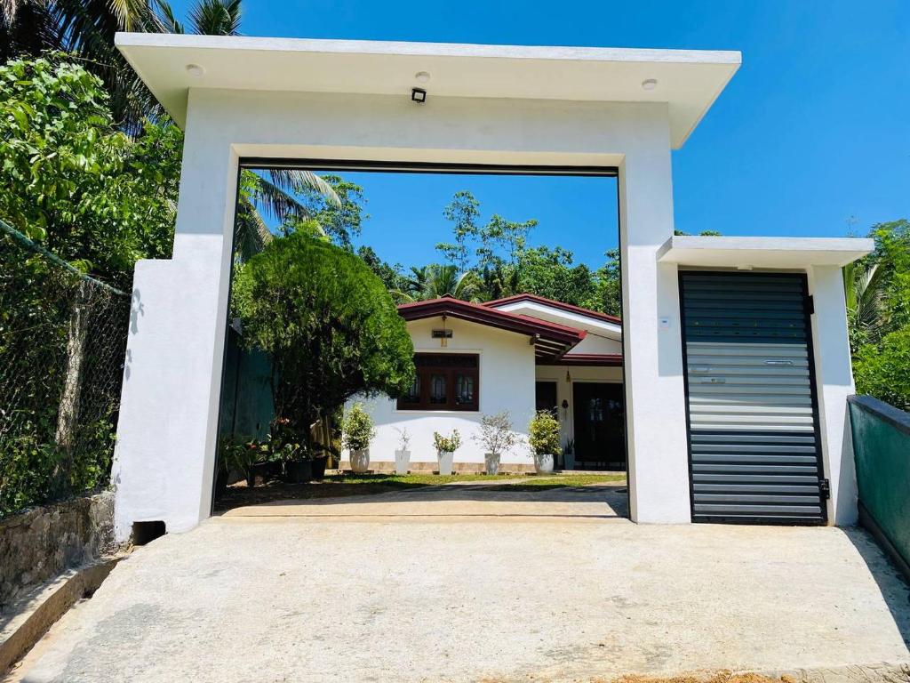 Biały dom z drzwiami garażowymi przed nim w obiekcie Samashi Lucky Villa w mieście Galle