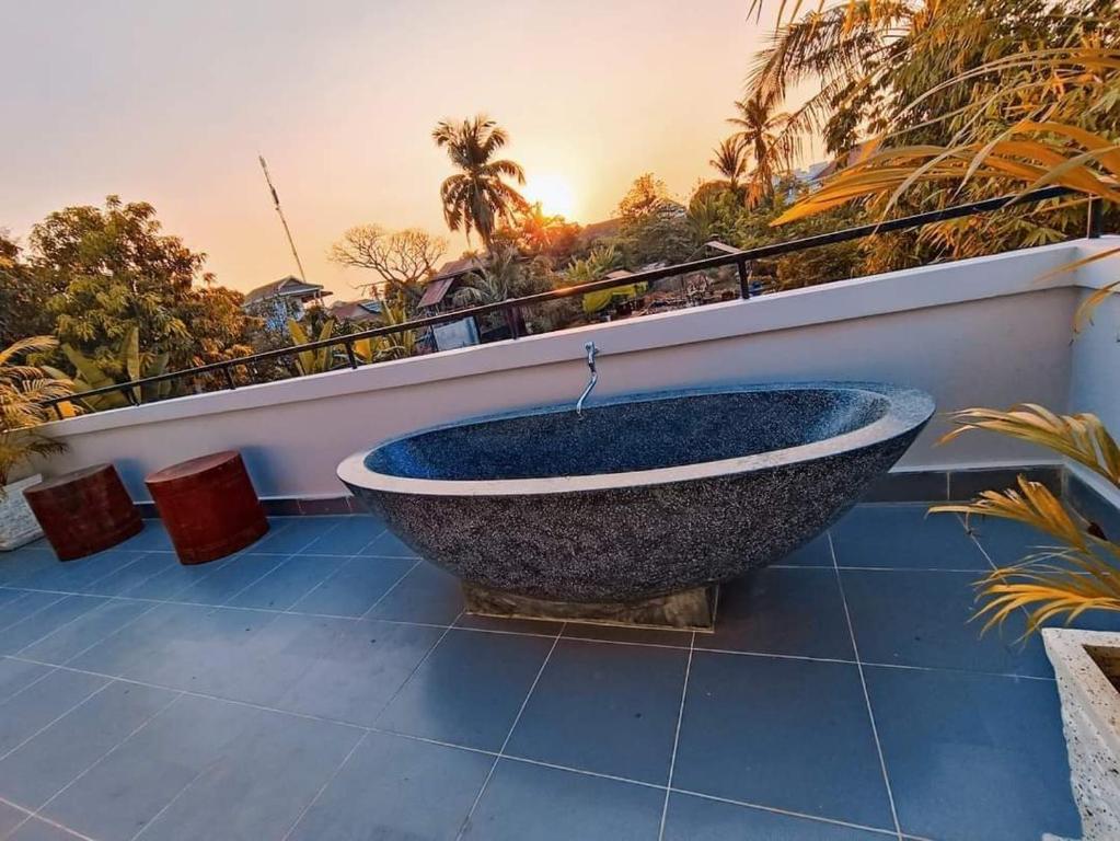 暹粒的住宿－Roya Khmer House，浴缸位于阳台顶部