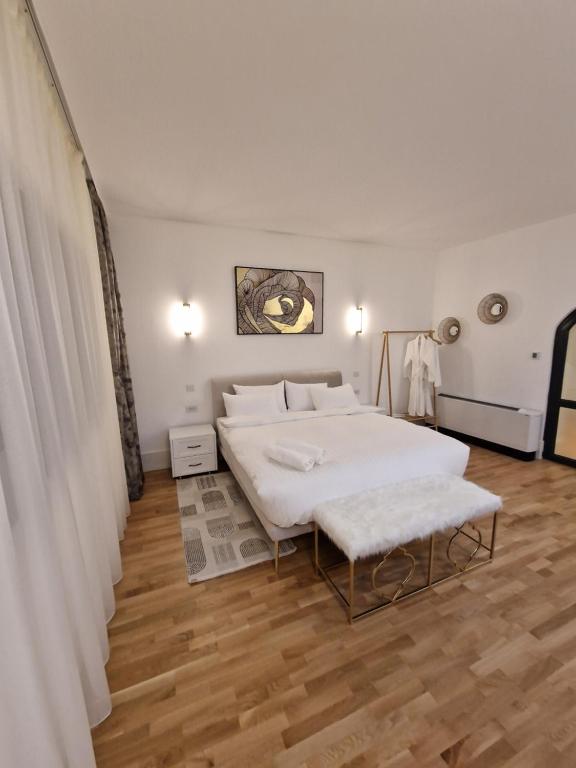 1 dormitorio con 1 cama blanca grande y suelo de madera en Rokebea Luxury, en Brasov