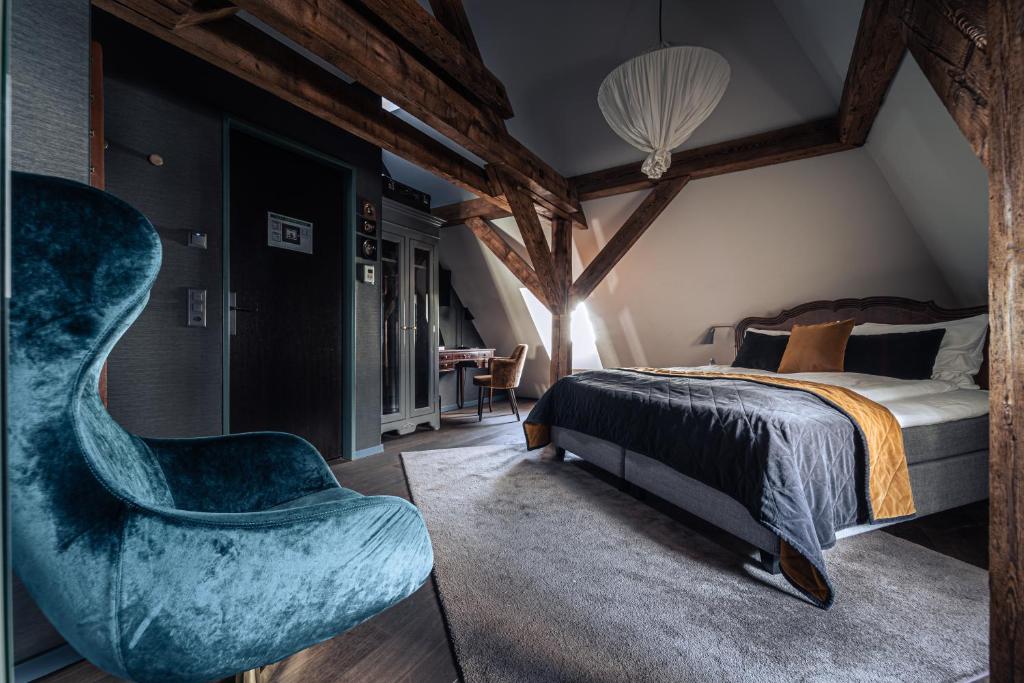a bedroom with a bed and a chair at Boutique Hotel Spedition a member of DESIGN HOTELS in Thun