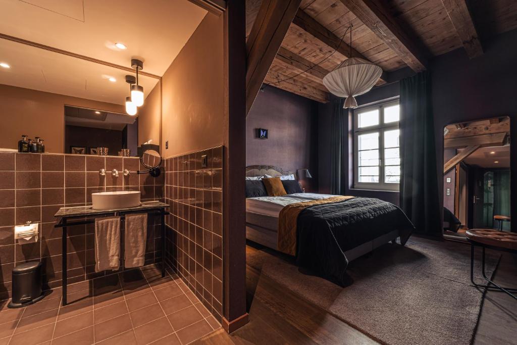 a master bathroom with a bed and a shower at Boutique Hotel Spedition a member of DESIGN HOTELS in Thun