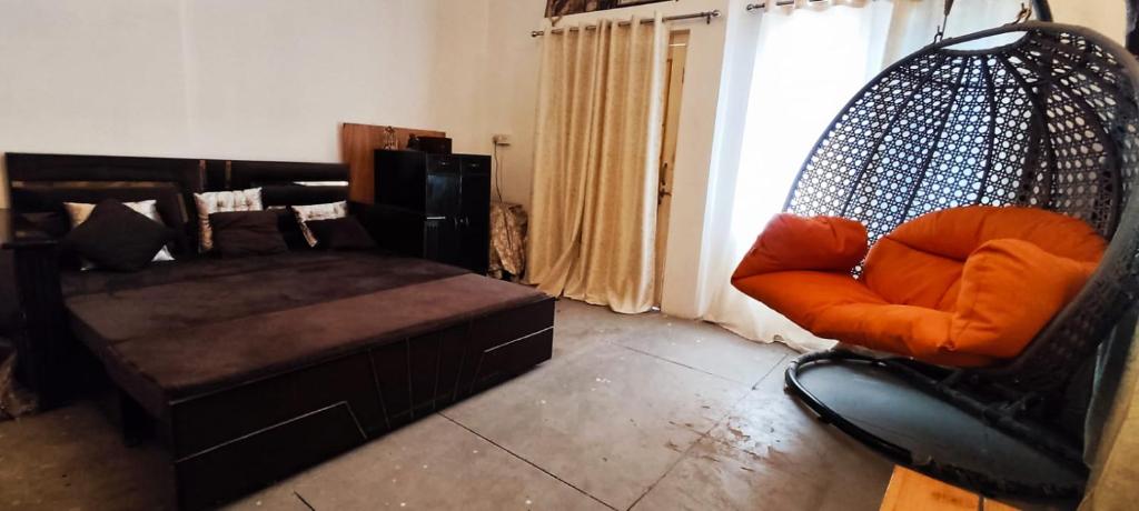 een woonkamer met een schommelstoel en een bank bij Ramashray - Spiritual कुटिया in Ayodhya