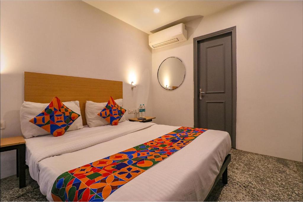 una habitación de hotel con una cama con una manta colorida en FabHotel La Serene Punjabi Bagh en Nueva Delhi