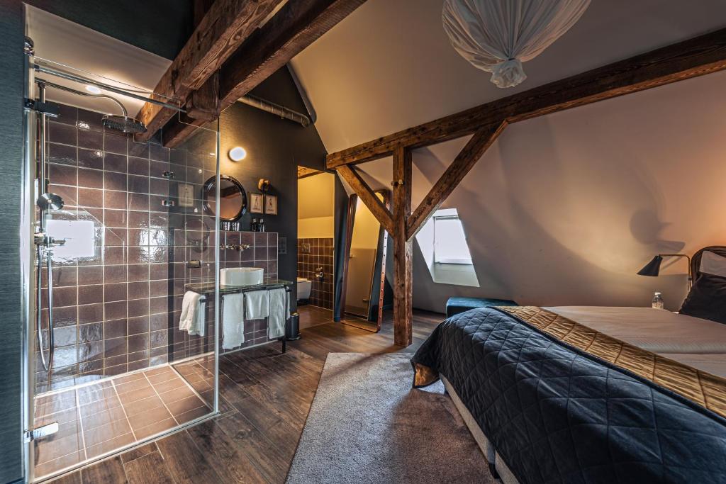 ein Schlafzimmer mit Dusche und ein Bett in einem Zimmer in der Unterkunft Boutique Hotel Spedition a member of DESIGN HOTELS in Thun