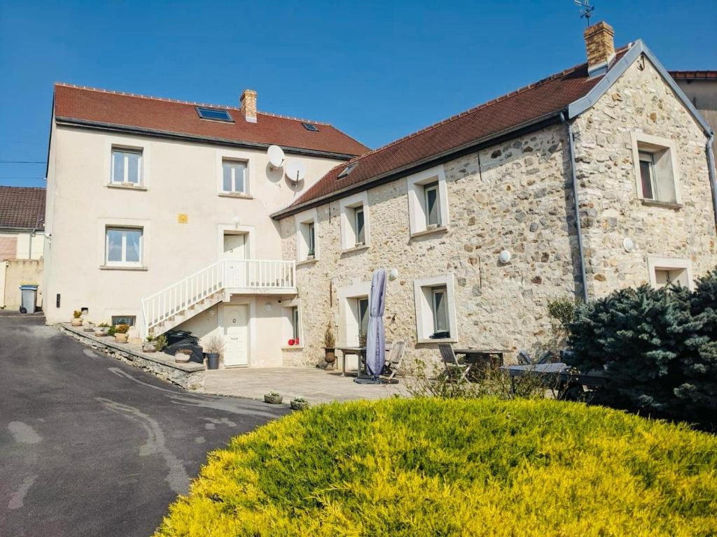 una grande casa in pietra su una strada di Domaine de famille Dovie a Château-Thierry