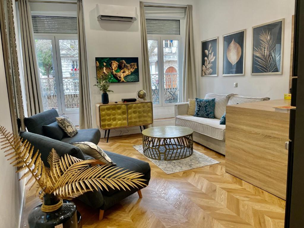 uma sala de estar com um sofá e uma mesa em Ô portes du Palais em Avignon
