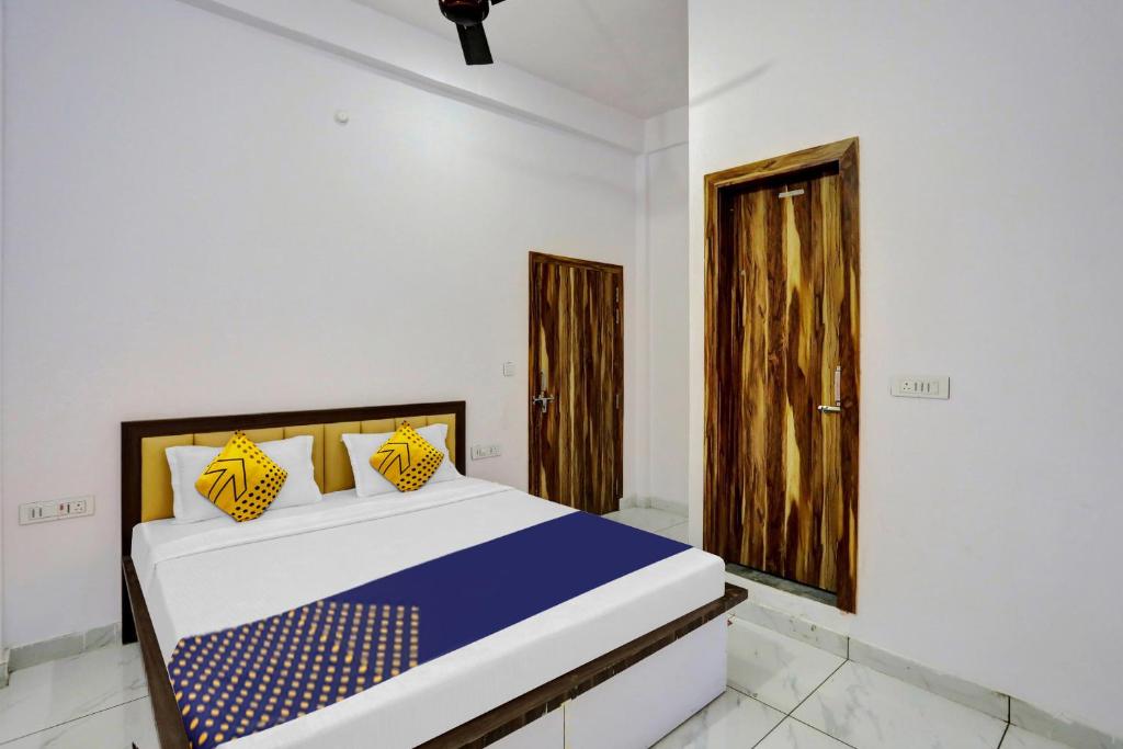 a bedroom with a bed and a wooden door at OYO Flagship Sardarji Hotel And Restaurant in Bāzpur