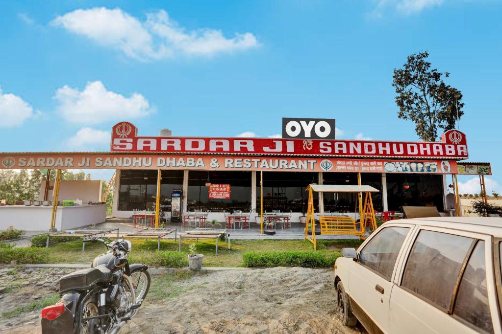 a car parked in front of a building with a sign at OYO Flagship Sardarji Hotel And Restaurant in Pushpagiri