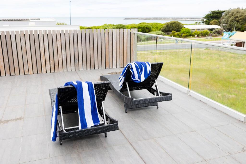 two chairs with towels on them sitting on a balcony at The Apollo in Apollo Bay