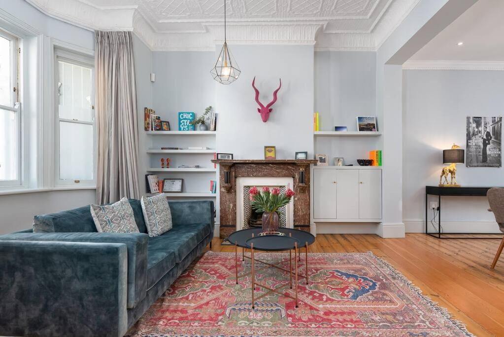 a living room with a couch and a fireplace at Victorian Townhouse with Table Mountain Views in Cape Town