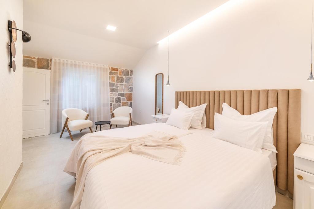 a bedroom with a large white bed with white pillows at Nono Ban Hotel & Villa in Gornji Humac