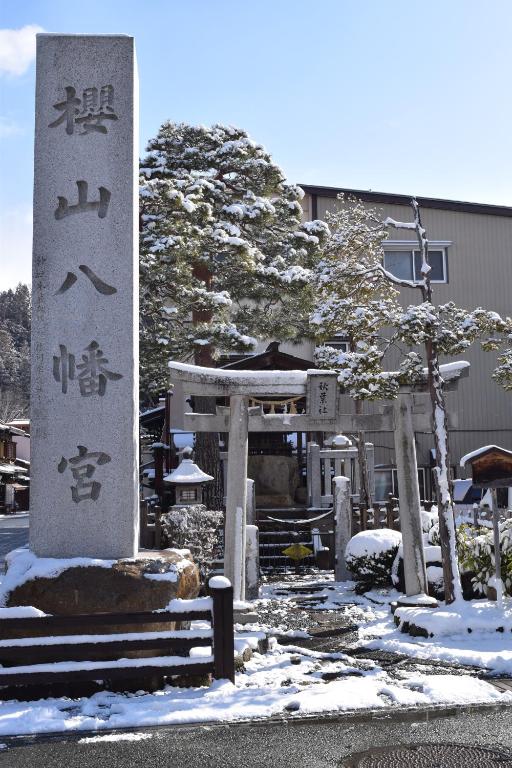 un cartel en la nieve frente a un edificio en Karin House, en Takayama