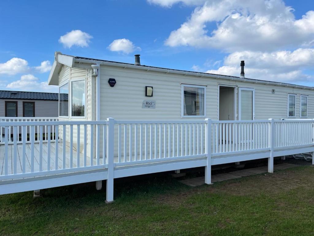 a white mobile home with a white fence at GDs Luxury Caravan Hire Turnberry Holiday Park in Turnberry