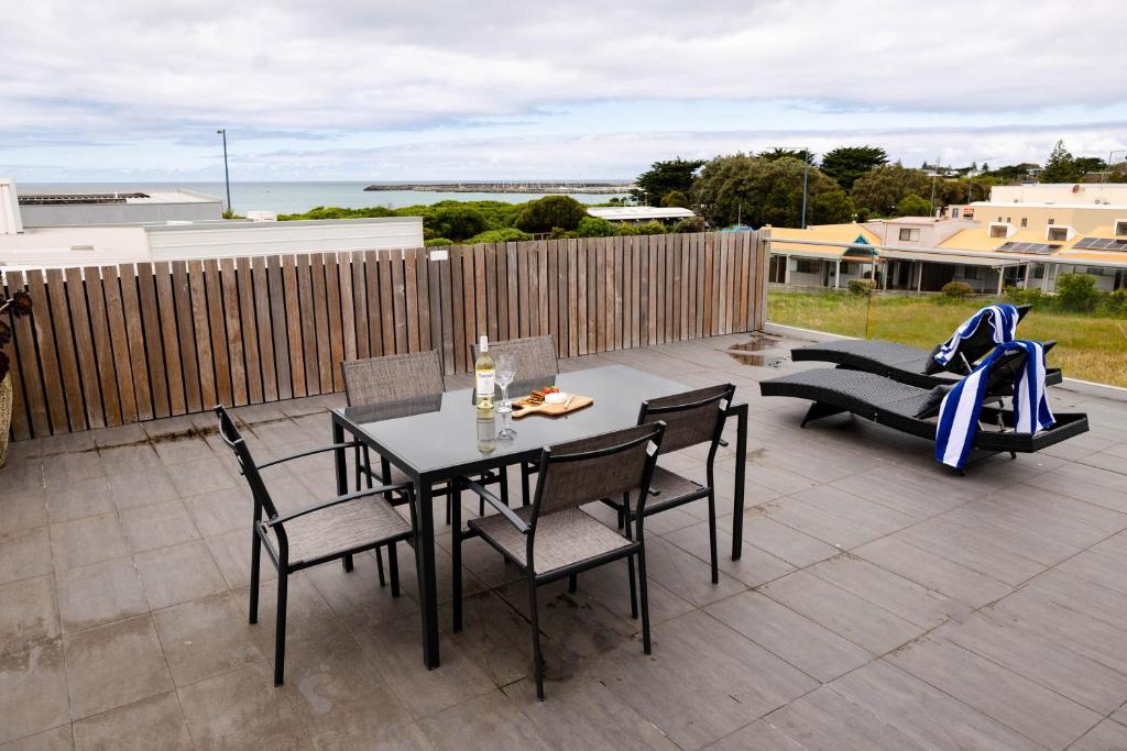 a patio with a table and chairs and a couch at The Apollo in Apollo Bay
