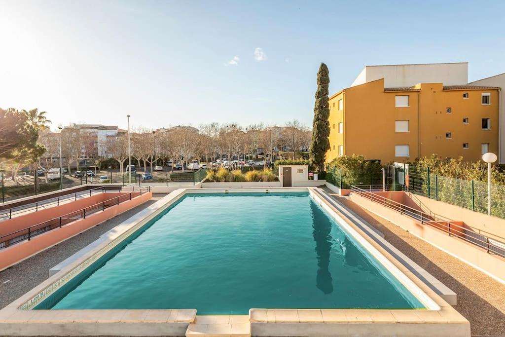 une grande piscine en face d'un bâtiment dans l'établissement Appart avec piscine, entre plage, port et falaises, au Cap d'Agde