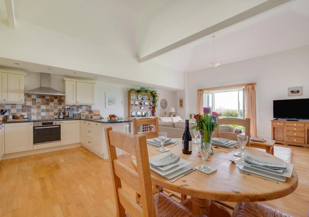 a kitchen and dining room with a wooden table at Pengliddon No.5 in Wadebridge