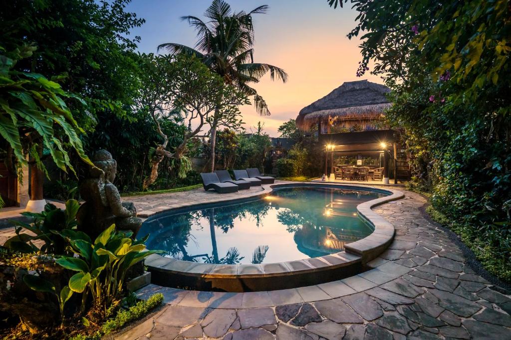 een zwembad in een achtertuin met een huis bij Villa Sujati in Ubud
