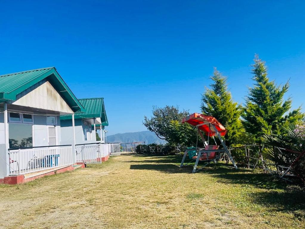 a yard with a playground next to a house at SnowDrop eco resort in Chail