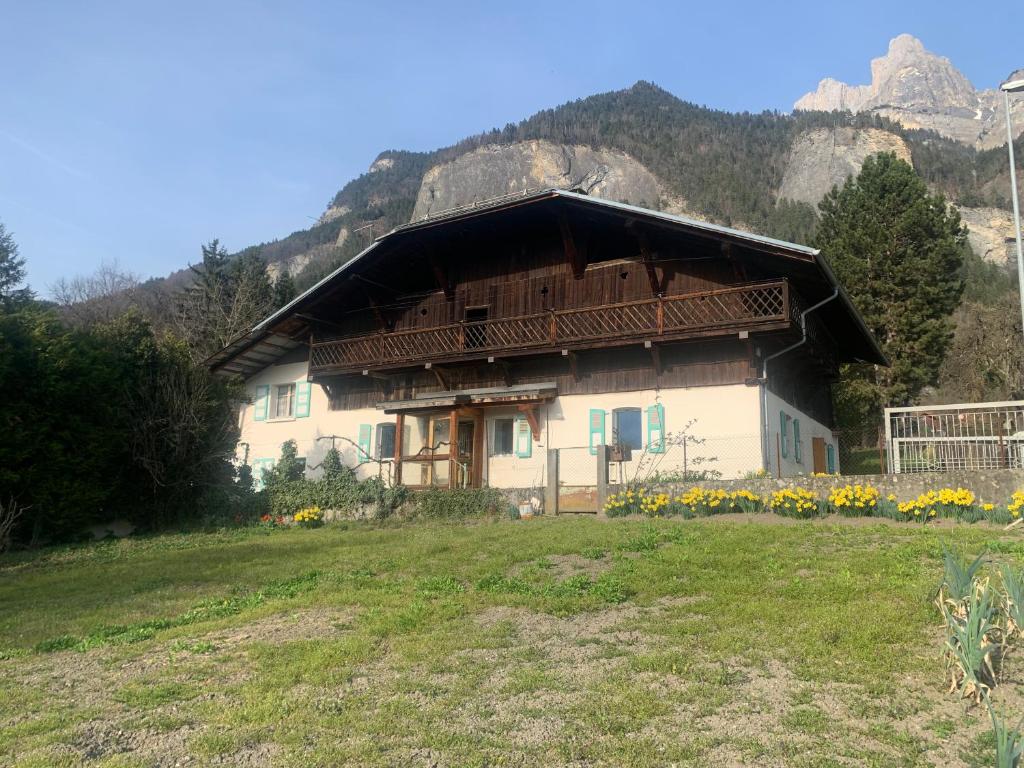 a house on a hill with flowers in front of it at Chalet Savoyard 6 pers vue panoramique Chez Mani in Sallanches