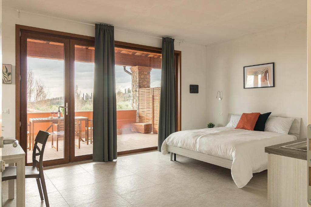 una camera con letto e un balcone con tavolo di Agriturismo I sentieri del Vino - Lago Lucone a Polpenazze del Garda