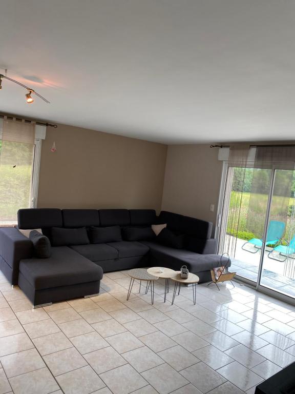 een woonkamer met een zwarte bank en een tafel bij Villa Fransesca in Ban-sur-Meurthe-Clefcy