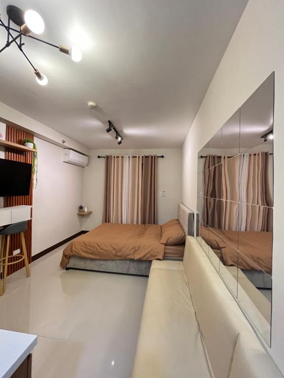 a bedroom with two beds and a couch at RichAirbnb Cebu in Lapu Lapu City