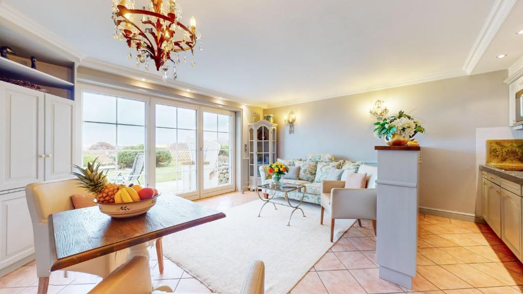 a kitchen and living room with a table and a dining room at Inselliebe in Munkmarsch