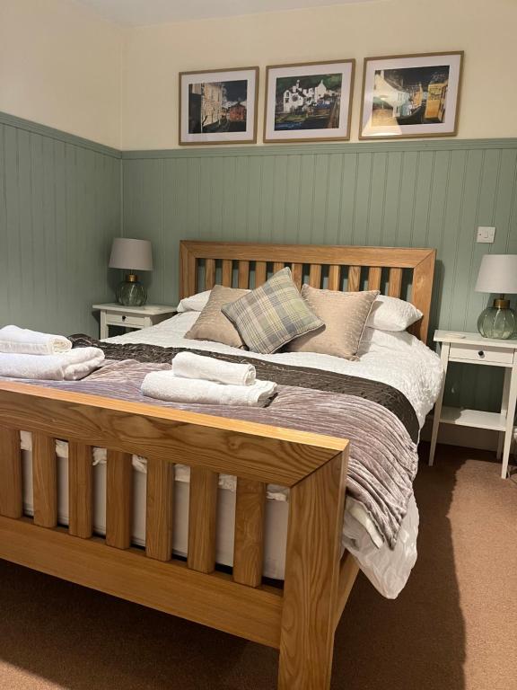 a bedroom with a large wooden bed with pillows at Daffodil Cottage in Cockermouth