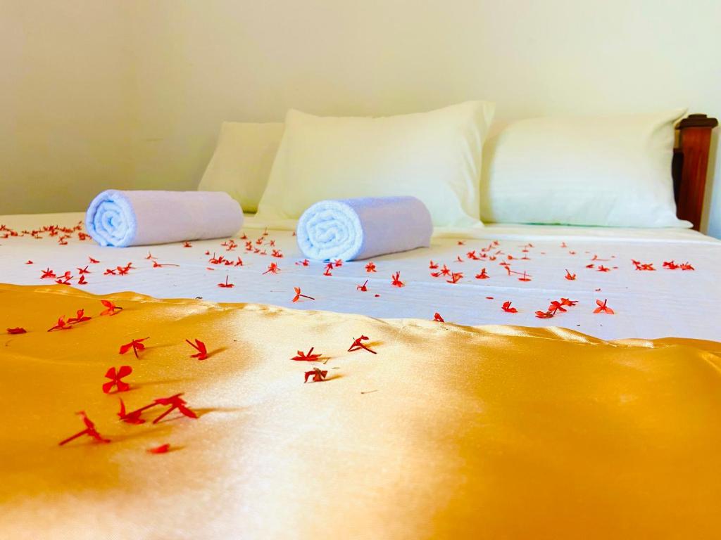 ein Bett mit roten Streuseln drauf mit einer Bettdecke mit Flugzeugen in der Unterkunft Marina Way Hotel in Arugam Bay