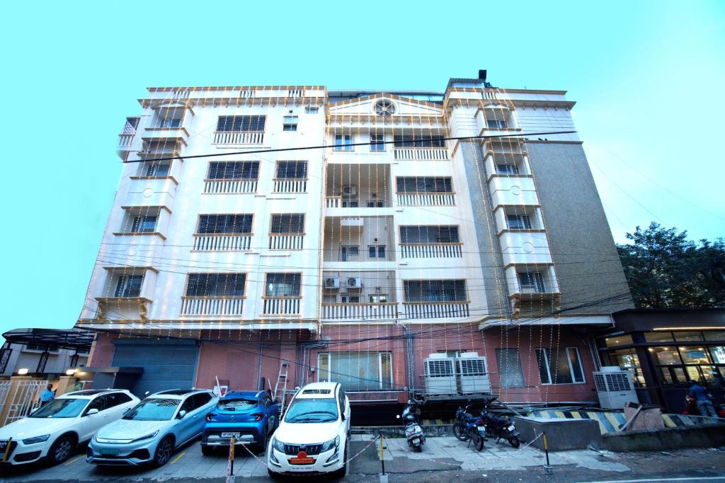 a building with cars parked in front of it at Blossoms Hotel & Service Apartments in Chennai